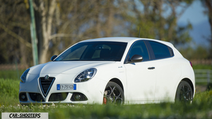 Alfa Romeo Giulietta QV Line – front three-quarter, white in a grassy field