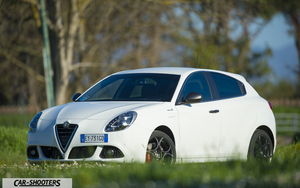 Alfa Romeo Giulietta QV Line – front three-quarter, white on a grassy field