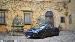 Peugeot RCZ Fullhd – front three-quarter, black in a courtyard