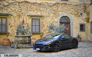 Peugeot RCZ Retina – front three-quarter, black parked in a stone courtyard