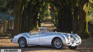 Jaguar XK 120 Fullhd – side profile, silver on a country road