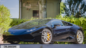 Lamborghini Huracan Fullhd – front three-quarter, dark blue parked outdoors near foliage