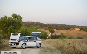 Lancia Delta HF Integrale Martini 5 – front three-quarter, white on a dirt road with hills