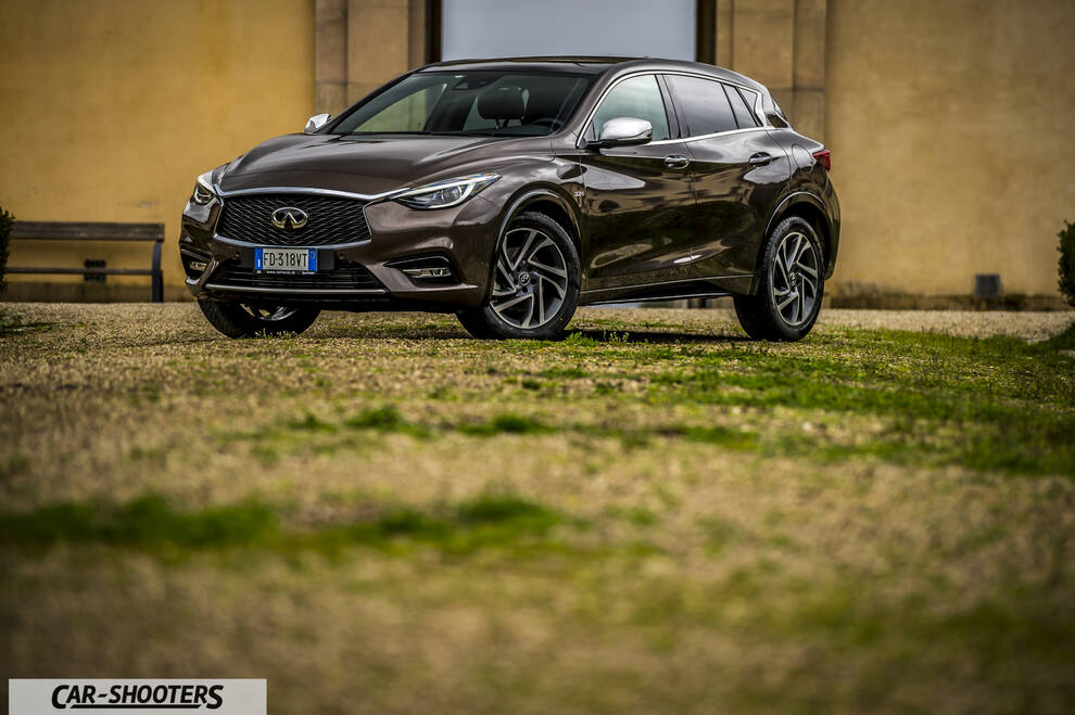Infiniti Q30 – front three-quarter, brown metallic parked on a gravel courtyard