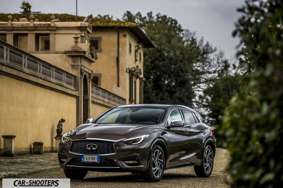 Infiniti Q30 – front three-quarter, brown metallic against a historic building