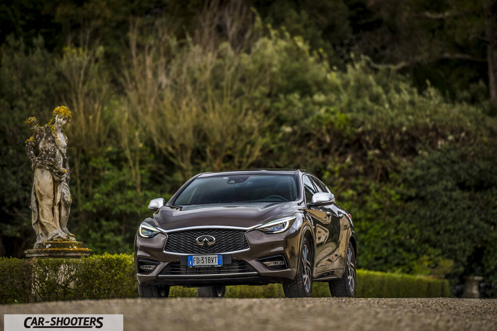 Infiniti Q30 – front three-quarter, brown metallic on a park road with a statue