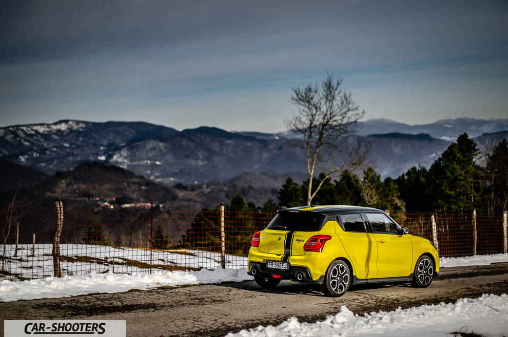 Suzuki Swift Sport – rear three-quarter, yellow against a mountain backdrop