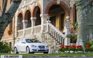 Jaguar XF Retina – front three-quarter, white in front of a historic building