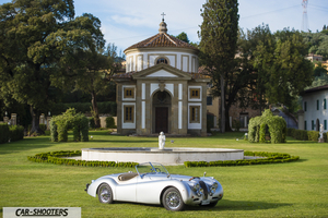 Jaguar XK 120 – front three-quarter, silver in front of a historic building