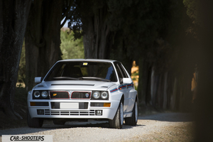 Lancia Delta HF Integrale Martini 5 – front three-quarter, white on a dirt road lined with trees