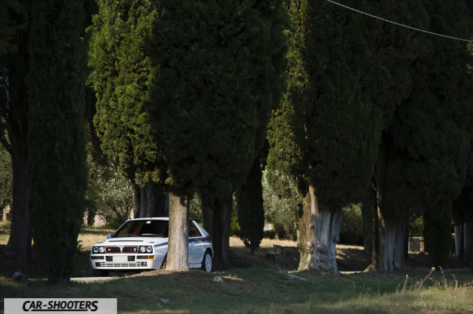 Lancia Delta HF Integrale Martini 5 – front three-quarter, white framed by tall trees