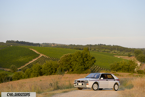 Lancia Delta HF Integrale Martini 5 – front three-quarter, white on a dirt road in a countryside landscape