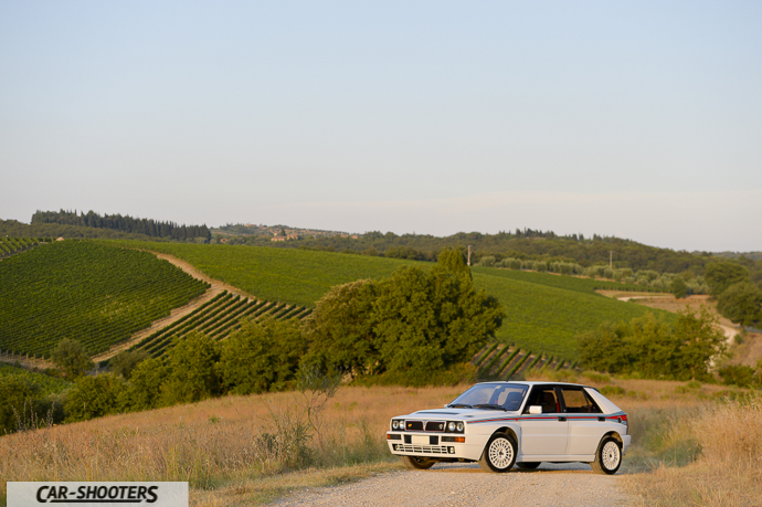 Lancia Delta HF Integrale Martini 5 – front three-quarter, white on a dirt road in a countryside landscape