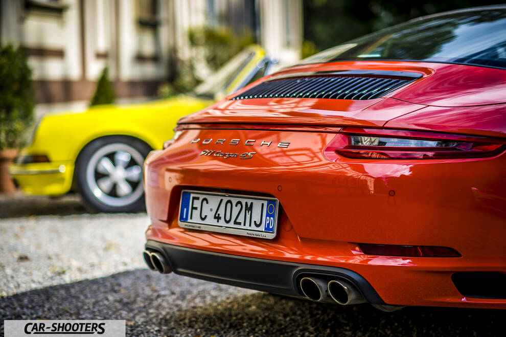 Porsche 911 Targa Storica – rear three-quarter, orange with another car parked behind