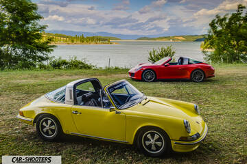 Porsche 911 Targa Storica – front three-quarter, yellow against a lake and mountain backdrop
