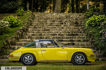 Porsche 911 Targa Storica – side profile, yellow parked in front of stone steps