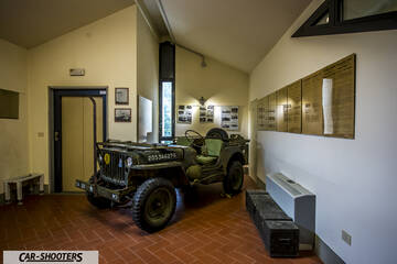 Alfa Romeo Mito Veloce Imola Mugello – front three-quarter, military green in an indoor exhibition room