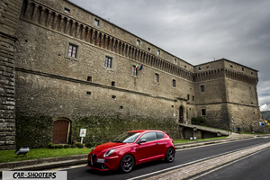 Alfa Romeo Mito Veloce Imola Mugello – front three-quarter, red against a stone castle wall