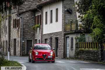 Alfa Romeo Mito Veloce Imola Mugello – front three-quarter, red on a village street