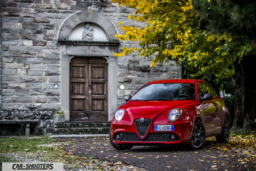 Alfa Romeo Mito Veloce Imola Mugello – front three-quarter, red against a rustic stone building