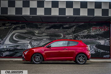 Alfa Romeo Mito Veloce Imola Mugello – side profile, red metallic against a track map mural