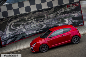 Alfa Romeo Mito Veloce Imola Mugello – front three-quarter, red against a track map backdrop