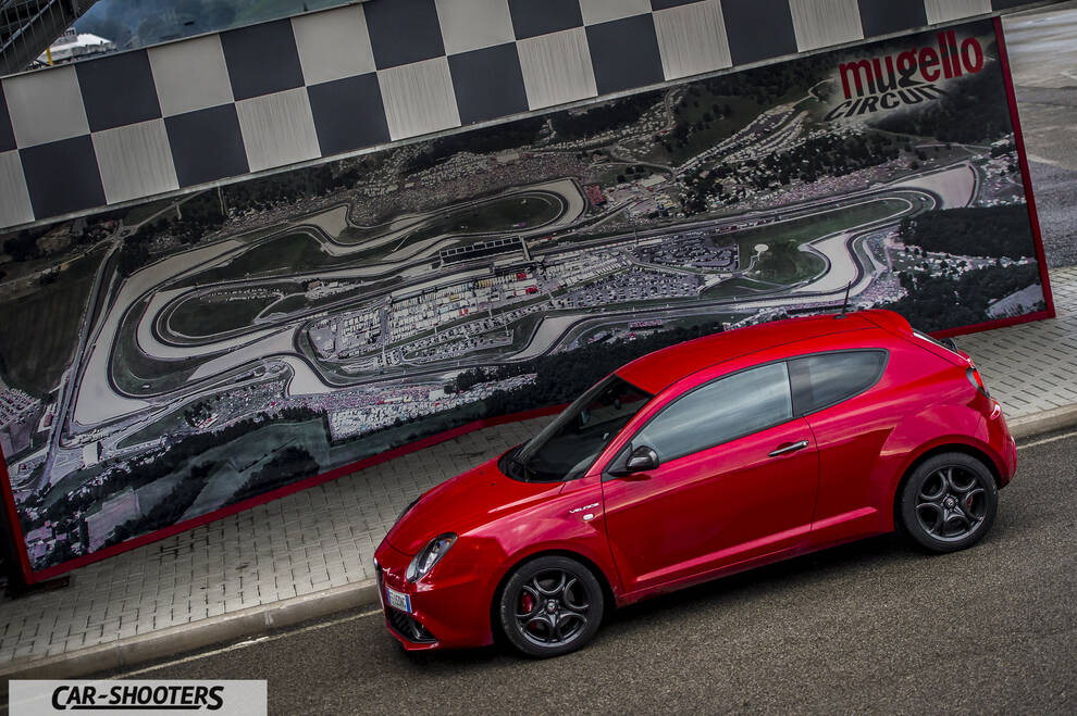 Alfa Romeo Mito Veloce Imola Mugello – front three-quarter, red against a track map backdrop
