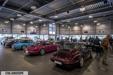 Porsche – rear three-quarter, dark red in a car showroom