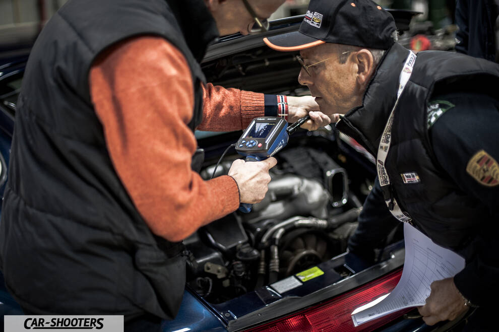Porsche – engine bay, two mechanics inspecting engine
