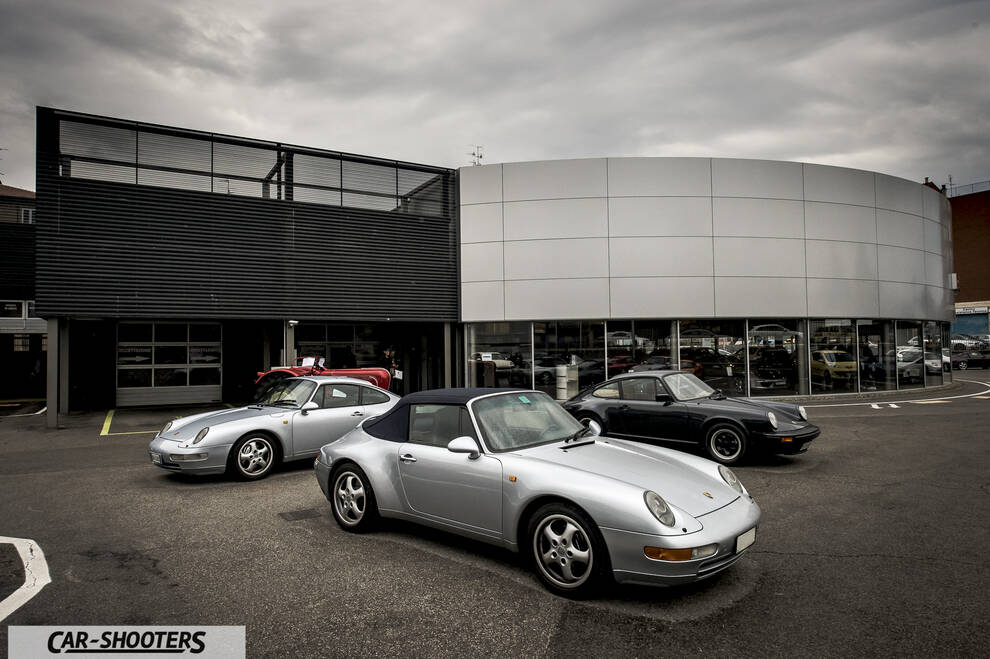 Porsche – front three-quarter, silver in a paved parking lot