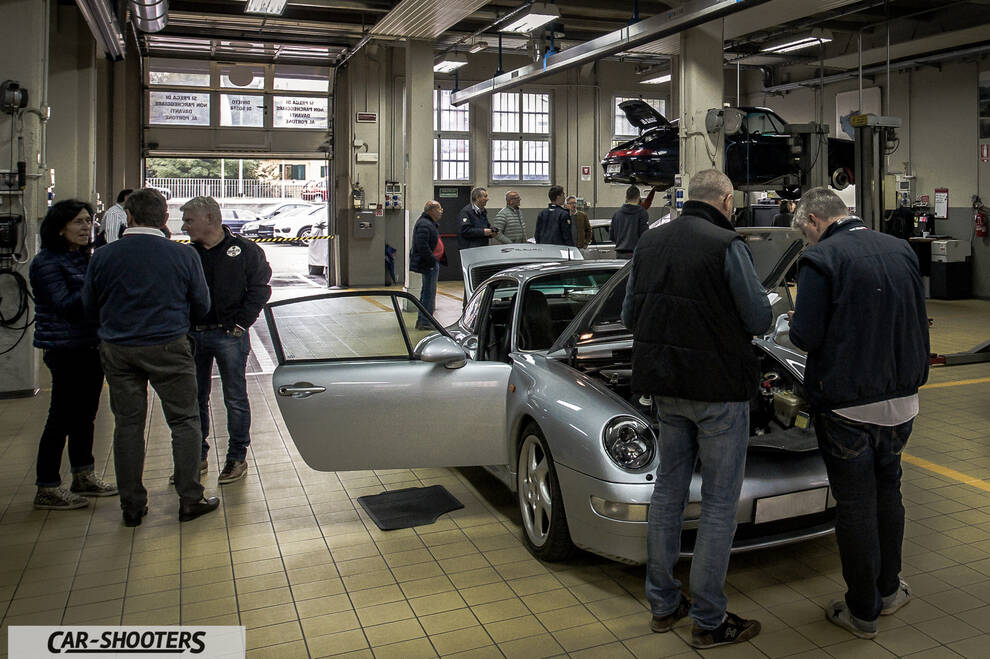 Porsche – front three-quarter, silver in a repair shop
