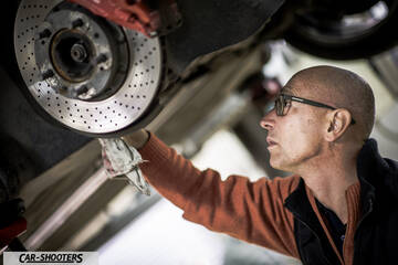Porsche – detail, mechanic inspecting brake disc