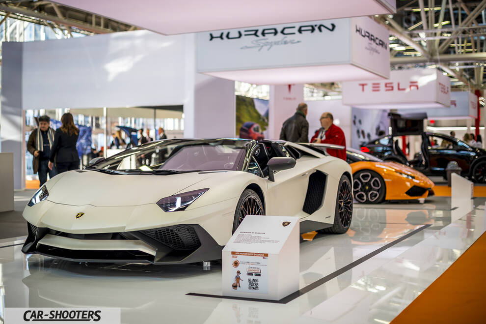 front three-quarter, matte white at an indoor auto show