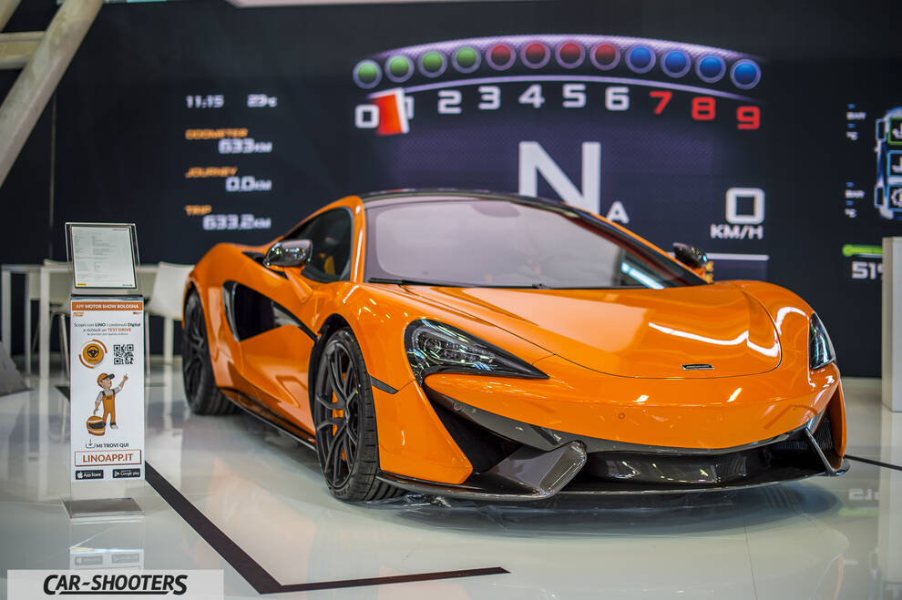 front three-quarter, orange at an indoor car show