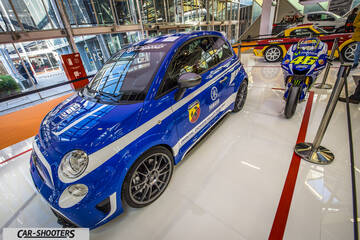 front three-quarter, blue in a modern exhibition hall