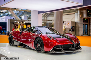 front three-quarter, red metallic at an indoor auto show