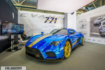 front three-quarter, blue chrome in an exhibition hall
