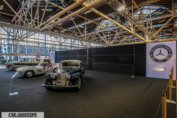 front three-quarter, dark blue in an indoor exhibition hall