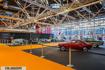 front three-quarter, red inside a car exhibition hall