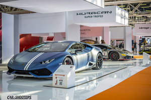 front three-quarter, matte blue at an indoor auto show