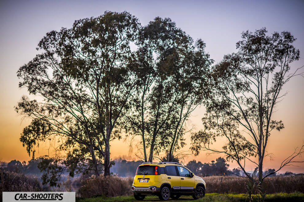 Fiat Panda 4X4 Cross – rear three-quarter, yellow against a sunset and trees backdrop