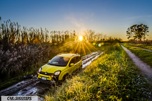 Fiat Panda 4X4 Cross – front three-quarter, yellow on a muddy path at sunset