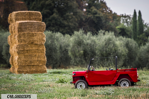 Fiat Super Scoiattolo – side profile, red in a grassy field with hay bales