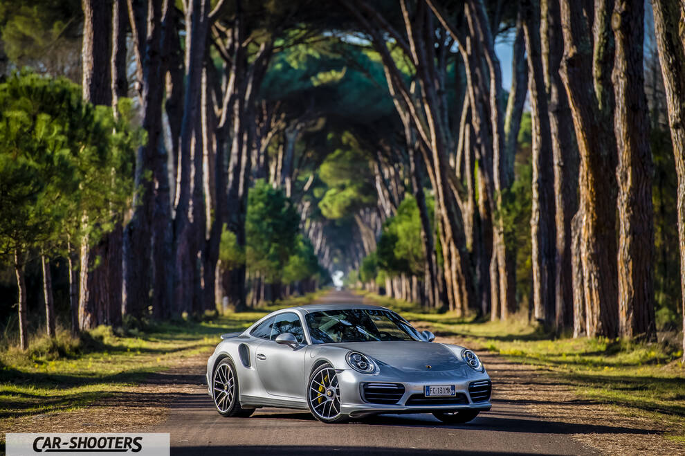 Porsche 911 Turbo S – front three-quarter, silver on a tree lined road