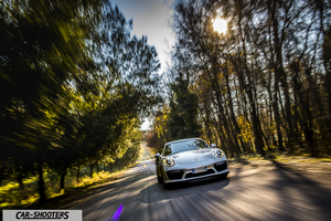 Porsche 911 Turbo S – front three-quarter, silver on a forest road