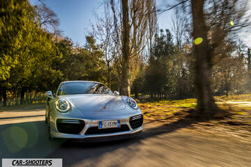Porsche 911 Turbo S – front three-quarter, silver driving on a country road