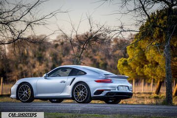 Porsche 911 Turbo S – rear three-quarter, silver on an empty road