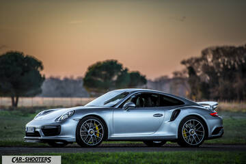 Porsche 911 Turbo S – side profile, silver against a sunset sky