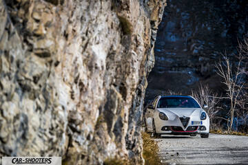 Alfa Romeo Giulietta Veloce – front three-quarter, white on a mountain road next to a rock wall