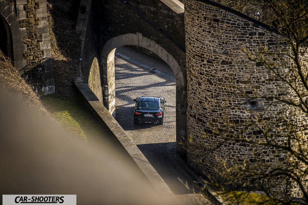 Toyota GT86 Namur – rear view, black driving under stone arches